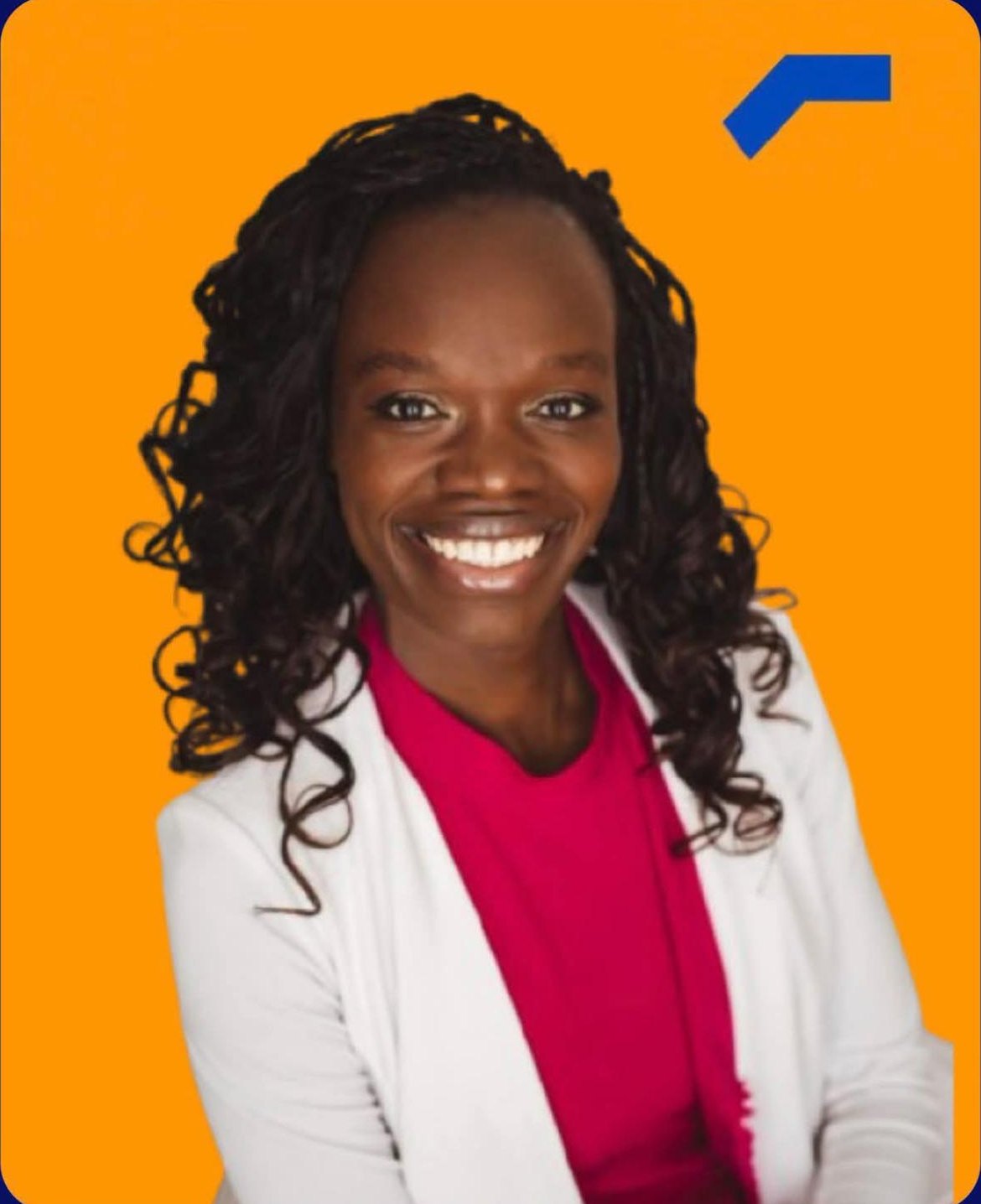 Portrait of Hon. Huldah Momanyi-Hiltsley, smiling, in a white blazer and magenta top against an orange background.